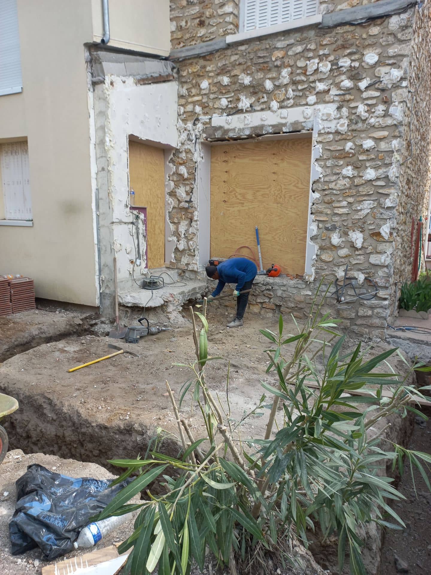 Terrassement des fondations au pied de la façade en meulière