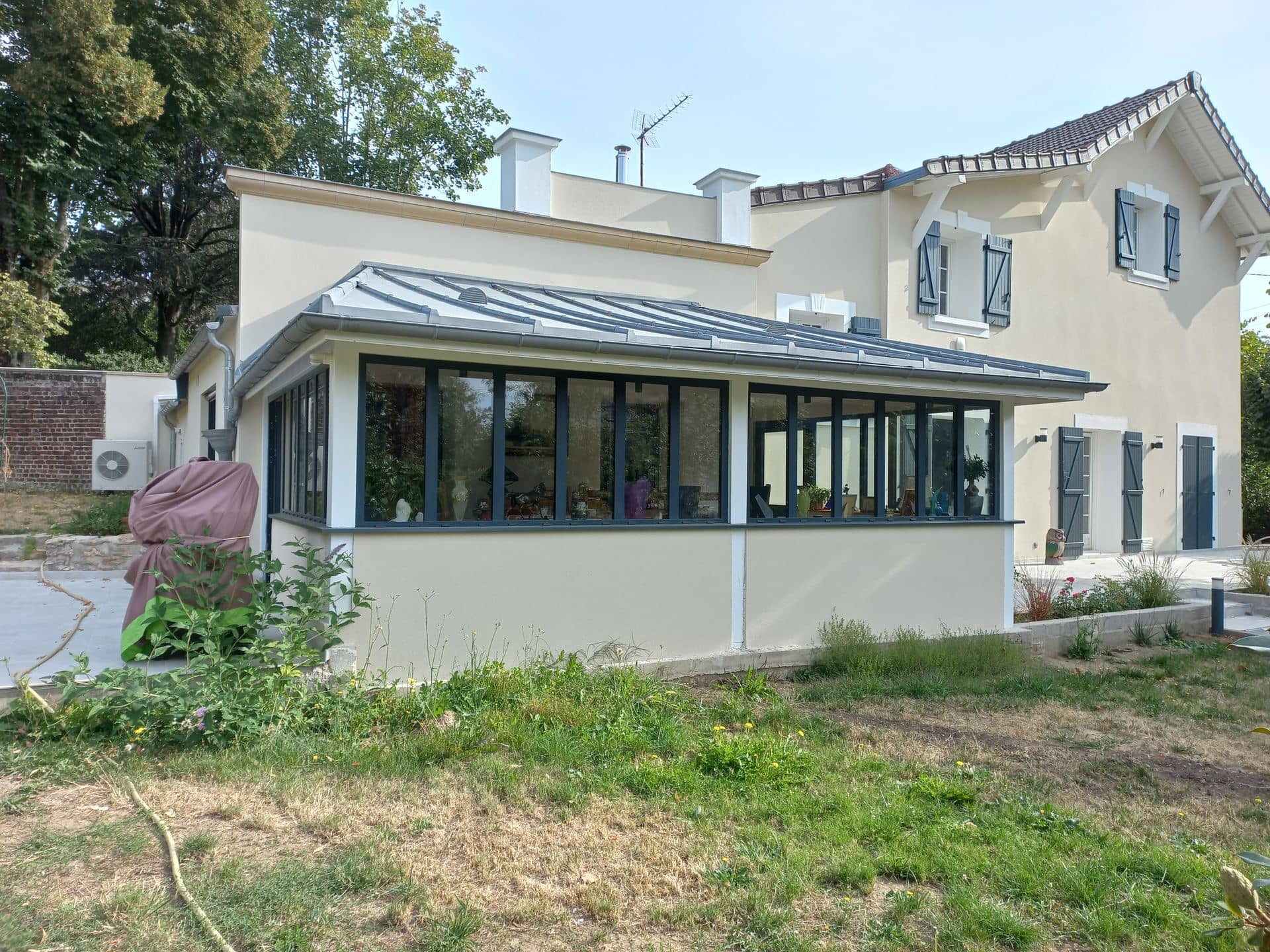 Extension vitrée sur allège maçonnée, toiture métallique en croupe