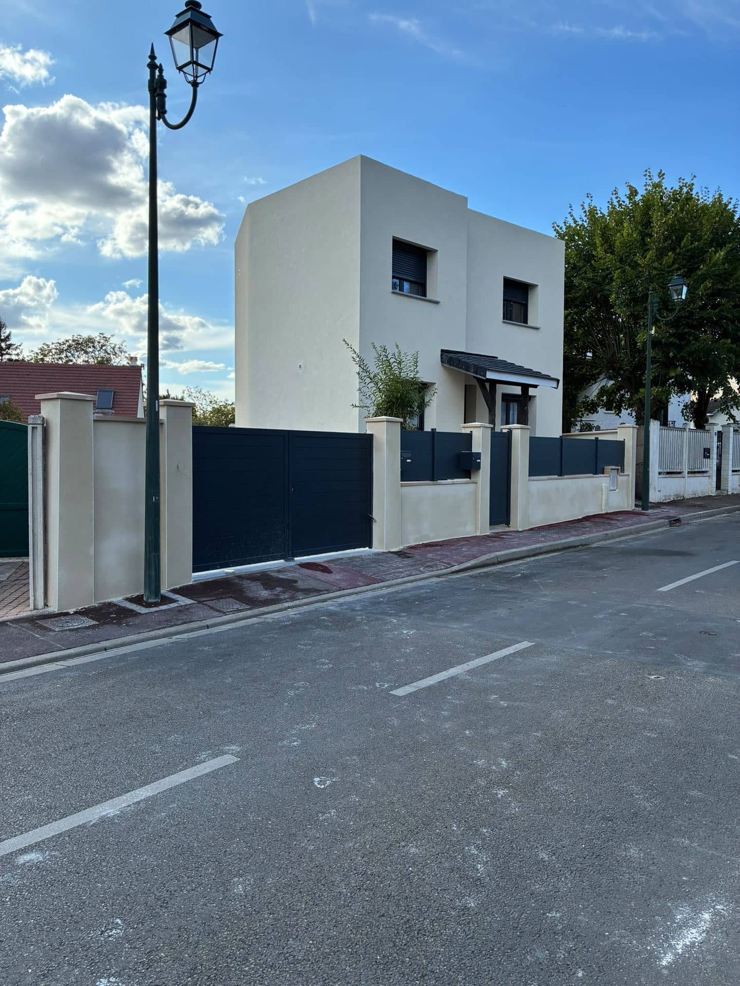 Maison cubique enduite avec clôture maçonnée neuve