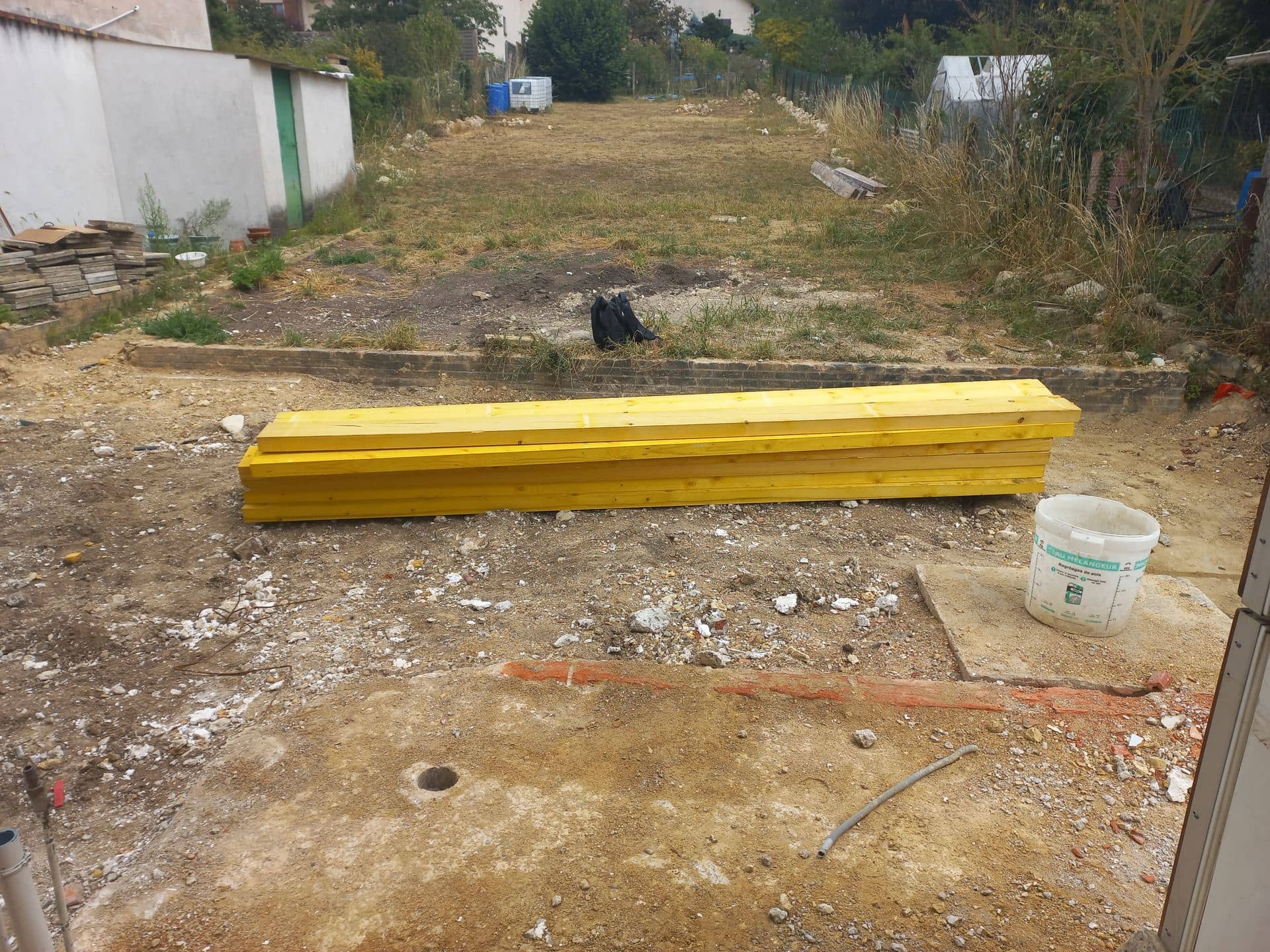 Jardin avant travaux, bastaings stockés au sol