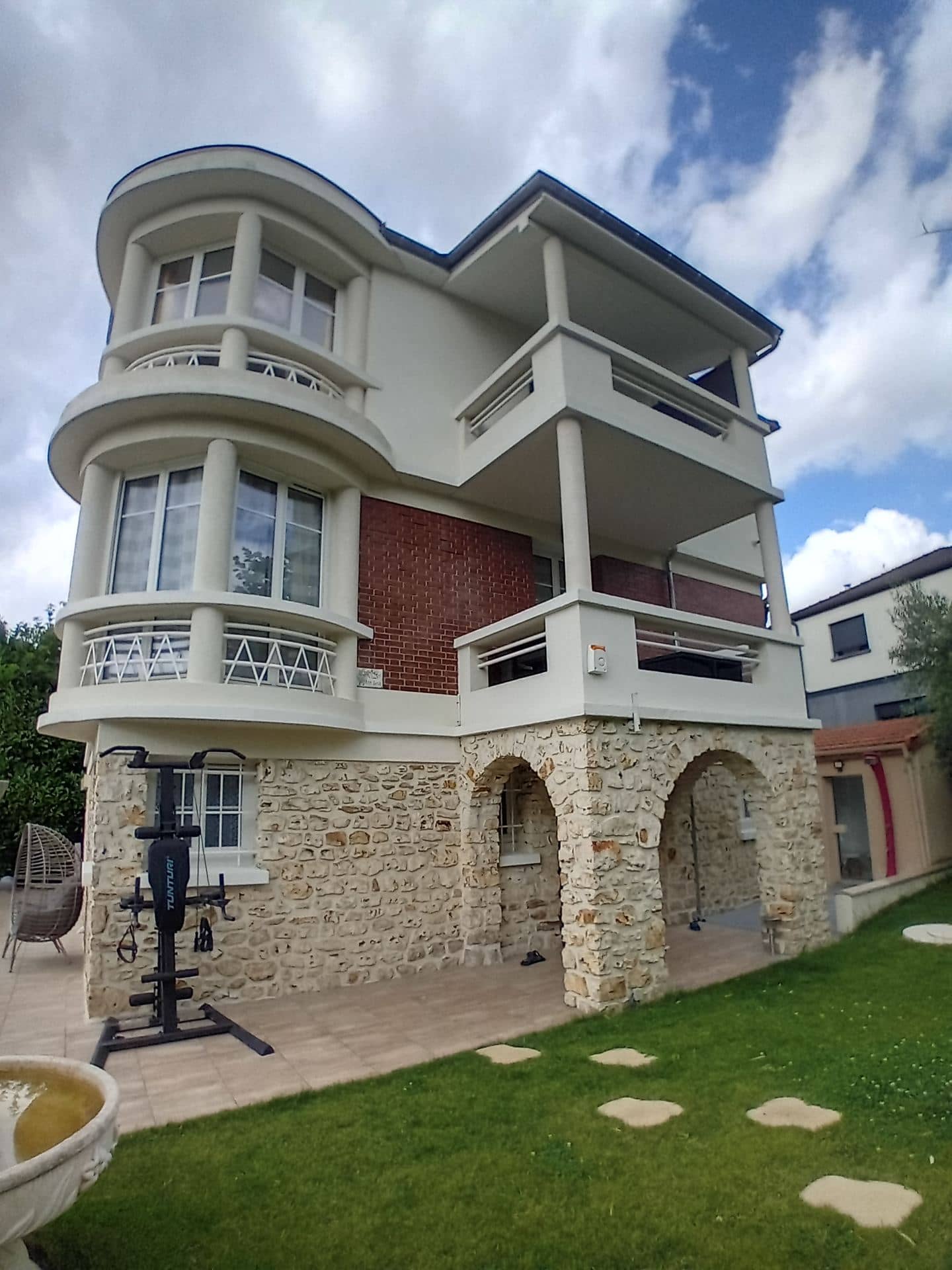 Maison surélevée : rotonde sur trois niveaux, balcons et loggia